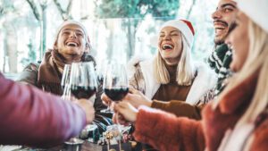 Friends wearing santa hats drinking wine
