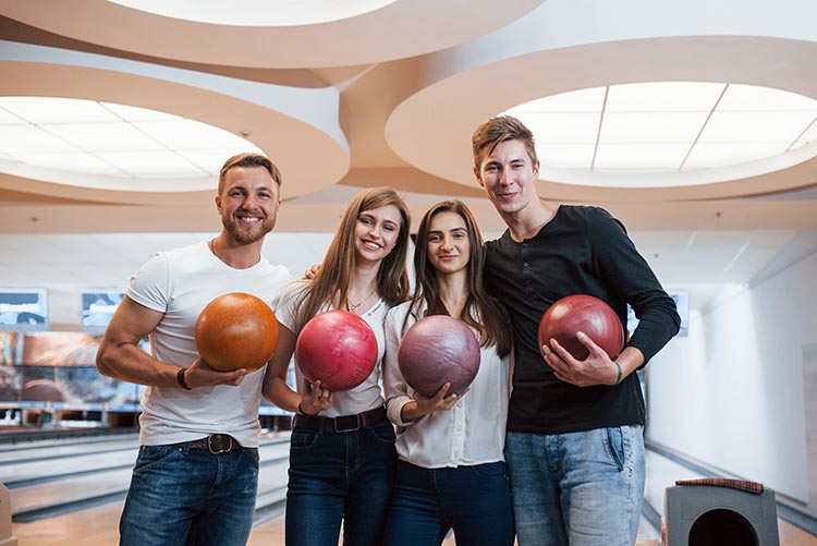 People standing holding bowling balls