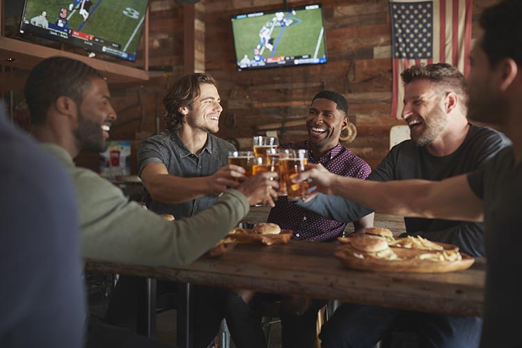 Friends Drinking and Eating In Sports Bar