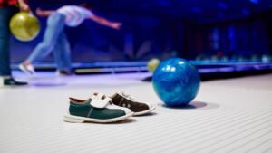 A bowling lane with shoes and a ball on it