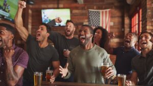 Men cheering at a bar over an American Football Game