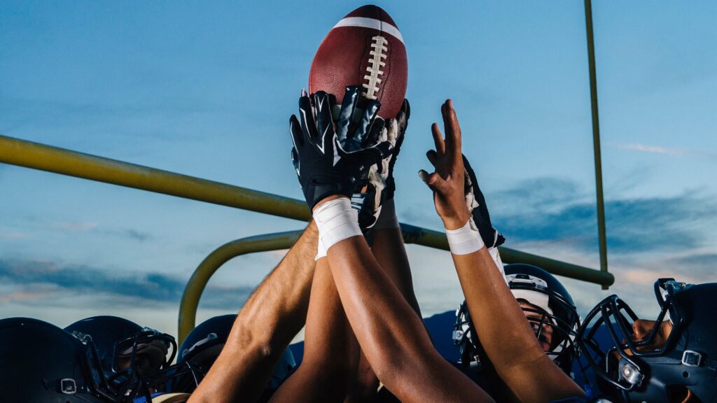 Men holding a football in celebration