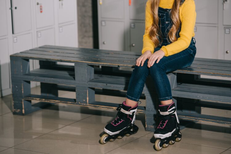 Girl Sitting on Bench With Roller Skates