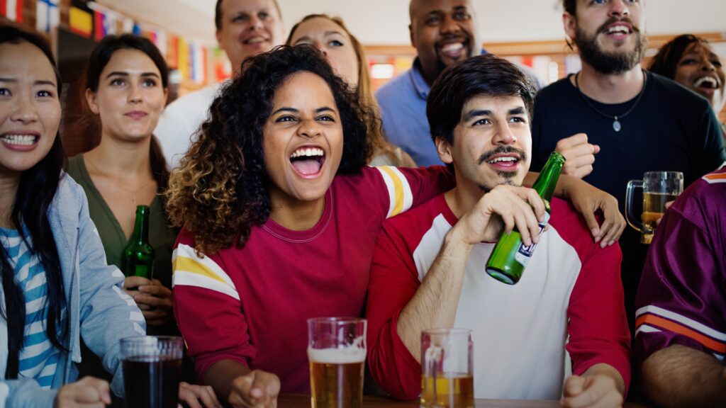 Friends celebrating watching a sports event with beer